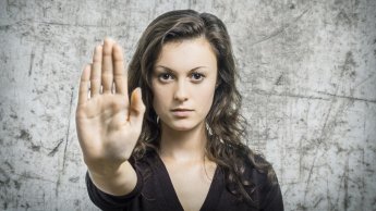 Frau hebt die Hand zu einer abwehrenden, selbstschützenden Geste