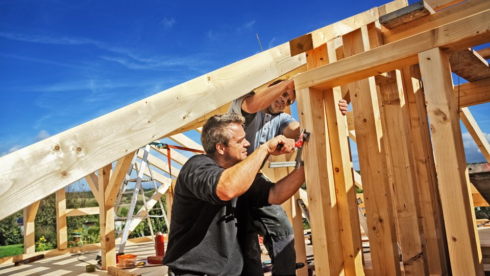 Zwei Männer bauen einen Dachstuhl 